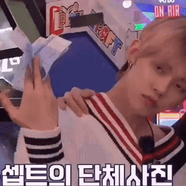 a man is holding a bunch of money in his hands in front of a machine .