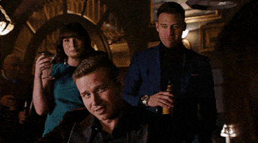 a woman in a blue dress is holding a martini glass