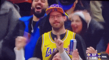 a man in a lakers jersey holds a can