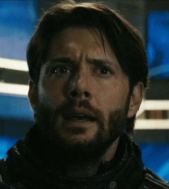 a man with a beard and scarf looks surprised