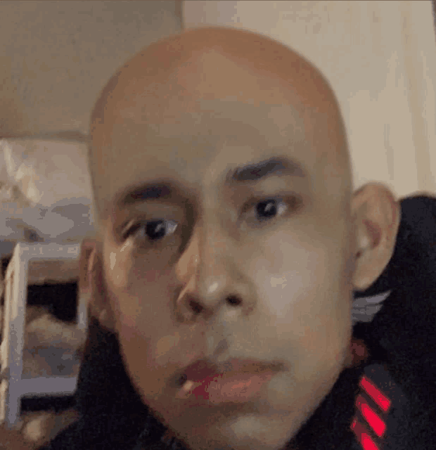 a close up of a man 's face with a bald head and red lips
