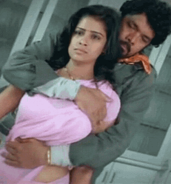 a man with a beard is holding a woman in his arms