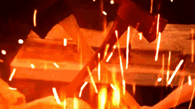 a hammer is being thrown into a fire and sparks are flying