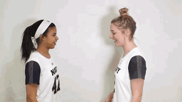 two female athletes wearing jerseys with the number 12 on them