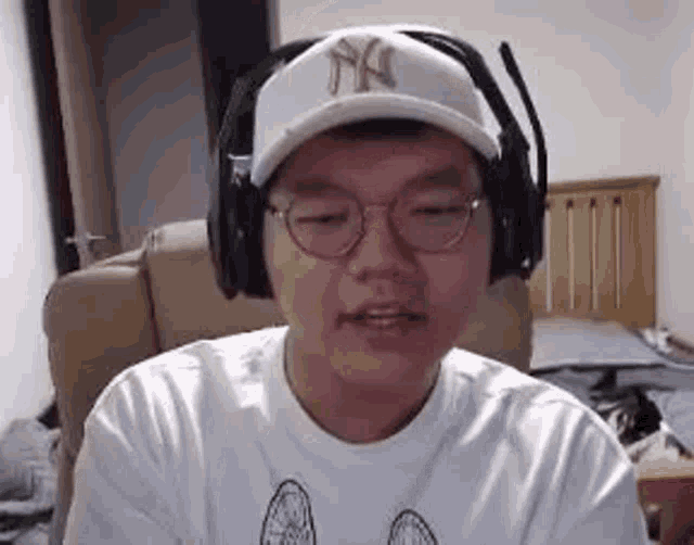 a man wearing glasses and headphones is sitting in a chair .