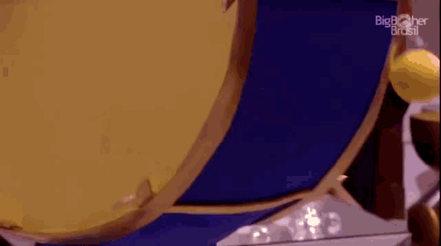 a person is playing a drum with a drum stick and a yellow ball .