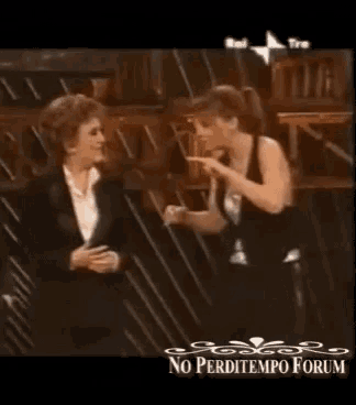two women are standing next to each other on a stage with the words no perditempo forum on the bottom .