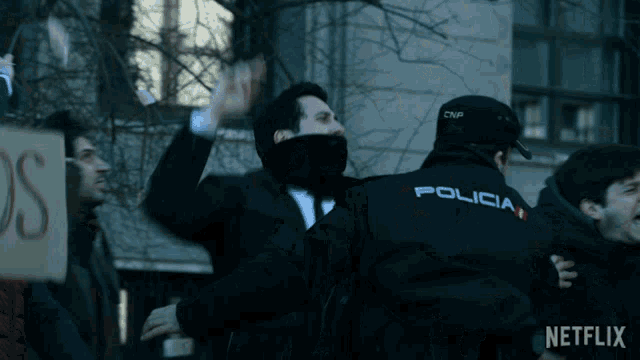 a man in a black jacket with the word policia on the back of it