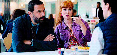 a man and a woman are sitting at a table in a restaurant talking to each other