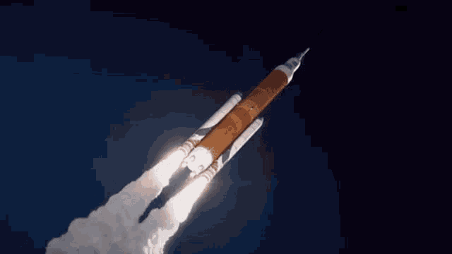 a rocket is flying through the air in a dark blue sky .