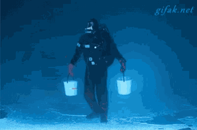 a scuba diver is pouring a bucket of water into a wheelbarrow ..