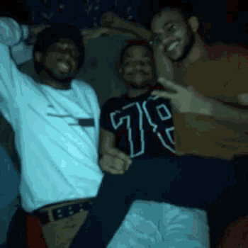 three men are posing for a picture and one of them is wearing a shirt with the number 79 on it