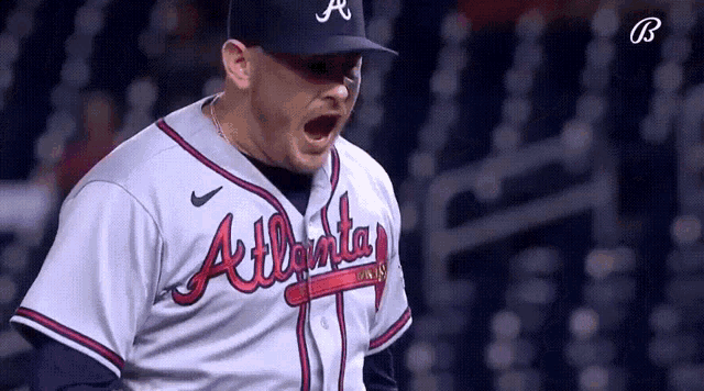 a man wearing an atlanta braves baseball uniform is screaming