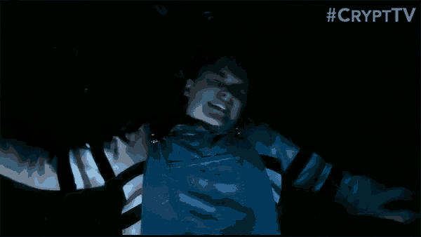 a person in overalls is standing in the dark with their arms outstretched