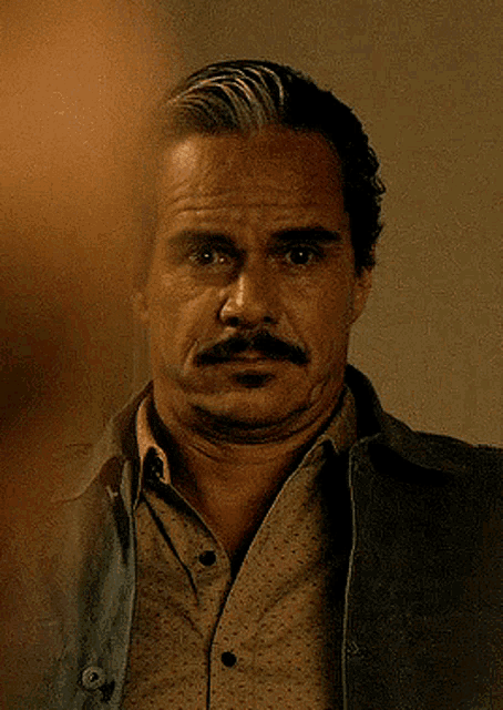 a man with a mustache wearing a shirt and jacket
