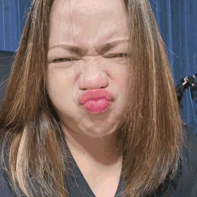 a woman making a face with her eyes closed