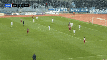 players on a soccer field with a banner that says soycare maxi
