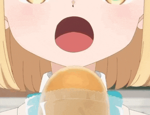 a close up of a girl eating a sandwich with her mouth open .