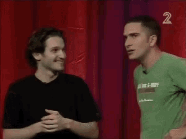 two men are standing next to each other on a stage and one of them is wearing a green shirt that says anna tomic
