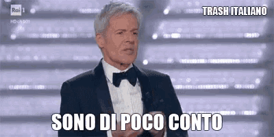 a man in a tuxedo and bow tie is standing in front of a crowd and says sono di poco conto .