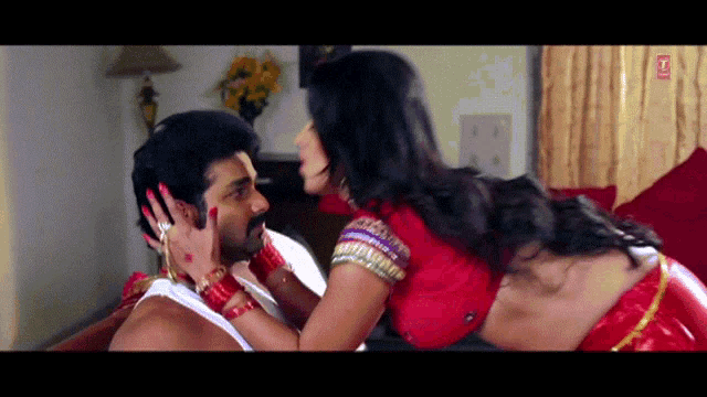 a woman in a red top is kissing a man on the cheek