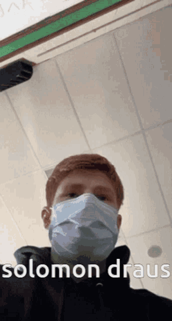 a man wearing a face mask says solomon draus on the bottom