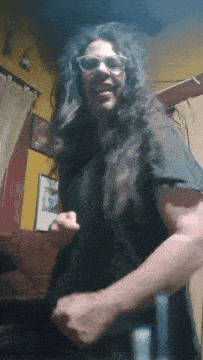 a man with long curly hair wearing sunglasses and a black shirt