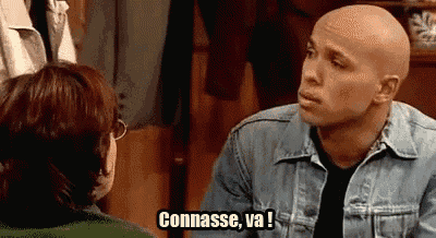 a bald man in a denim jacket is talking to a woman in a green jacket .