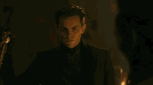 a man in a suit is standing in a dark room
