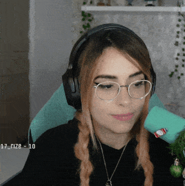 a woman wearing glasses and headphones is sitting in front of a microphone with the number 10 on the bottom right