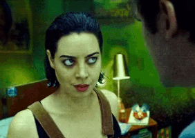 a man and a woman are looking at each other with a green background