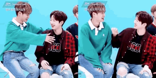 two young men are sitting next to each other and one of them is petting the other 's chest .