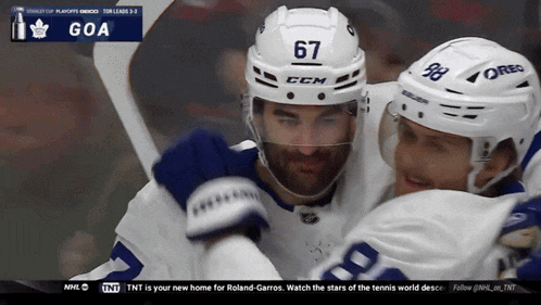 a hockey player with the number 67 on his helmet hugs another player