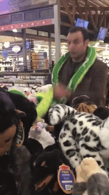 a man is surrounded by stuffed animals in a store and one of them has a tag that says fusion