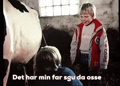 a boy in a red jacket is standing next to a cow with the words det har min far sgu da osse