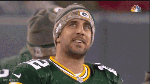a green bay packers player is wearing a beanie and smiling