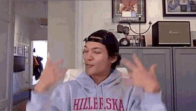 a person wearing a sweatshirt that says hizlerska