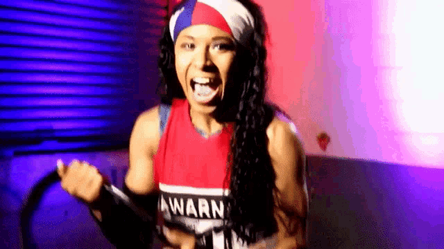 a woman is wearing a headband and a red and white tank top with the word awarn written on it .