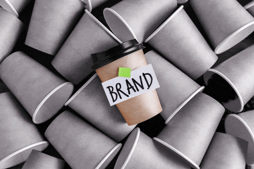 a cup of coffee with a sticky note that says brand