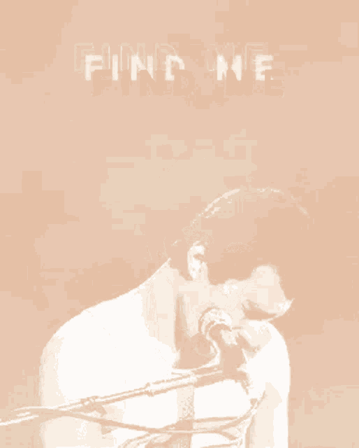 a man is singing into a microphone with the words find me behind him