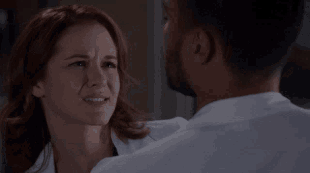 a man and woman are looking at each other in a dark room