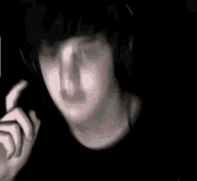 a blurry picture of a person 's face in a dark room .