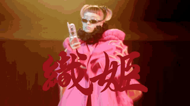 a woman in a pink coat is holding a cell phone in her hand