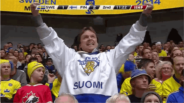 a man wearing a finland jersey stands in a crowd