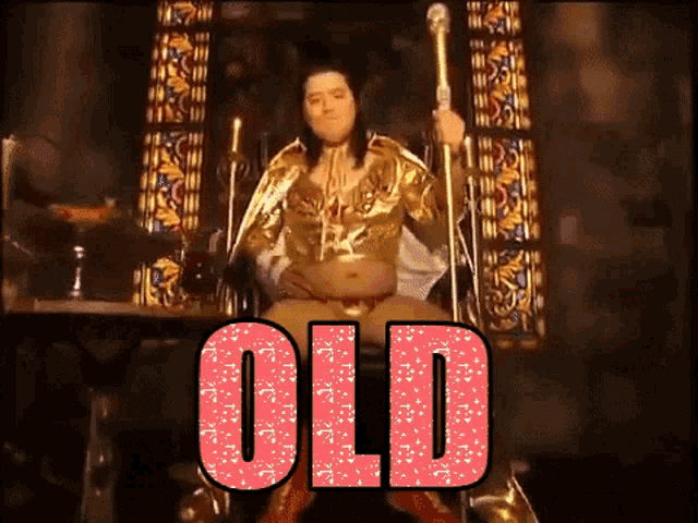 a man in a gold outfit is sitting on a throne with the word old on it