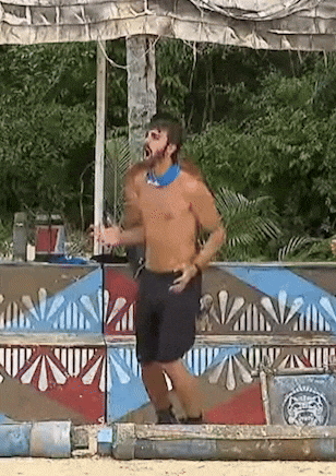 a shirtless man with a bandana around his neck is standing in front of a sign that says ' ain ' on it