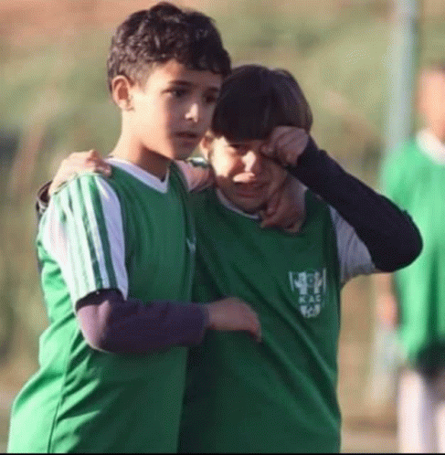 two young boys wearing green shirts with the word soccer on them