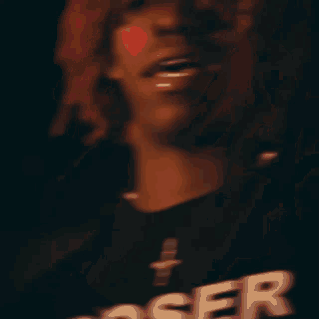 a blurry picture of a man with red hair wearing a shirt that says loser .