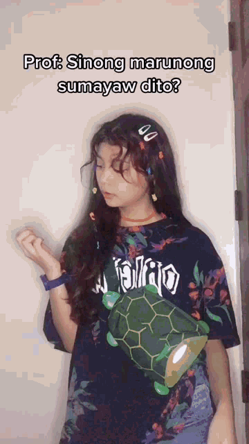 a girl wearing a black shirt with a turtle on it says prof sinong marunong sumayaw dito