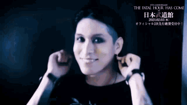 a man in a black shirt is making a peace sign with his hands